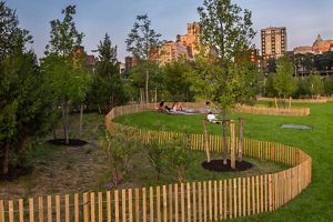 Gente relajándose en la zona de césped de un parque.