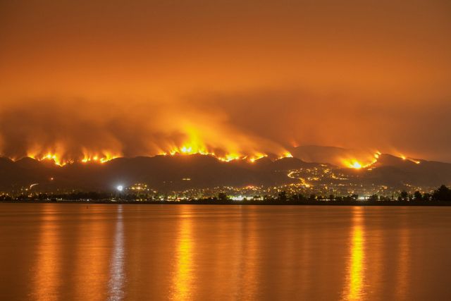 Photo of raging wildfire on the shores of a California lake.
