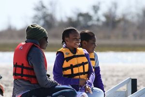 A family of three people enjoys a boat tour at Brownsville Preserve.