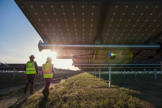 TNC's Laura Crane and a Fuller Star employee walking through the array of solar panels at the Fuller Star plant in Lancaster, California.