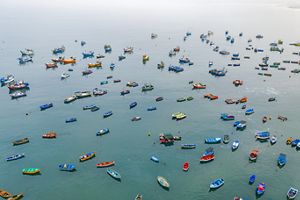 an aerial view of small, colorful fishing boats dotting the ocean