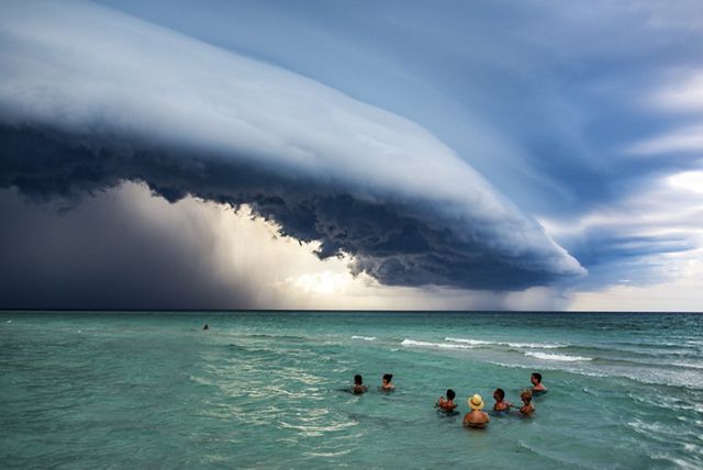 People in the ocean near Varadero, Cuba, watching a spectacular storm building over the ocean.