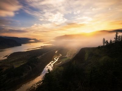 Sunrise over the Columbia River Gorge in Oregon. The fog rolls in over the Columbia River with hills and forests surrounding