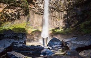 Water flowing from a waterfall into a glass.