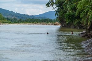 A river and its shore with hills in the background.