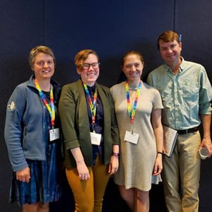A group of four smiling people at a conference.