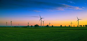Wind turbines in farm field at dusk.