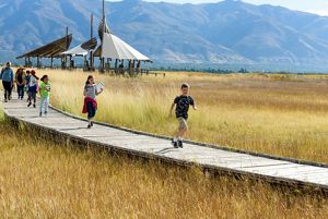 A group of kids running on a boardwalk.