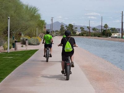 People bike along canal in AZ