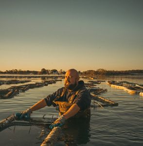 James “Bubba” Parker of Choptank Oyster Company harvests oysters from floating baskets off the company’s pier in Cambridge, Maryland.