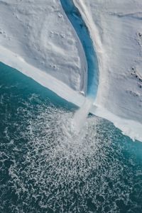 The iceshelf extends for hundreds of kilometres along the high arctic landscape. The jagged perfectly sculptured edges show the sheer magnitude of ice protruding into the ocean. 