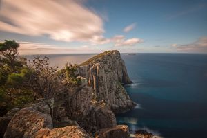 An aerial view overlooking a cliff to the ocean.
