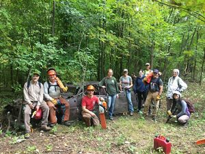 TNC staff and volunteers with tools in a forest.