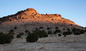 Sun setting on a large rocky outcropping on the mesa.