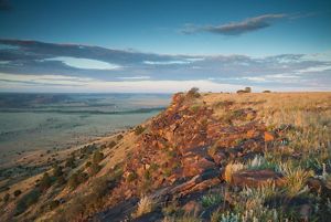 Looking down from the top of the mesa across a vast expanse of green valley.
