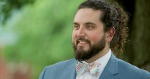 Photo of Boone Bowling wearing a blue blazer and colorful bowtie.