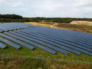 Renewable energy solar panel rows on shrubland.
