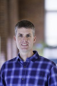 Bryan Emerson smiles in a portrait in an office.