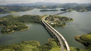 Vista aérea de uma rodovia de várias faixas que atravessa o reservatório de Atibaina, próximo à cidade de Nazaré Paulista, Brasil. O reservatório faz parte do sistema Cantarei