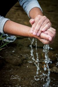 Um de nossos parceiros do projeto "Produtor de Águas" da The Nature Cconservancy Brasil lavando suas mãos em uma nascente em Rio Claro, Rio de Janeiro.