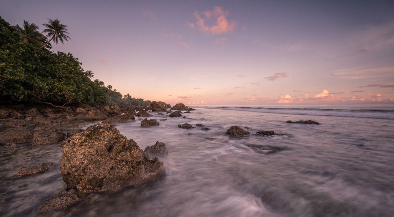 A view of the coastline at sunset near the village of Utwe on the island of Kosrae in Micronesia.