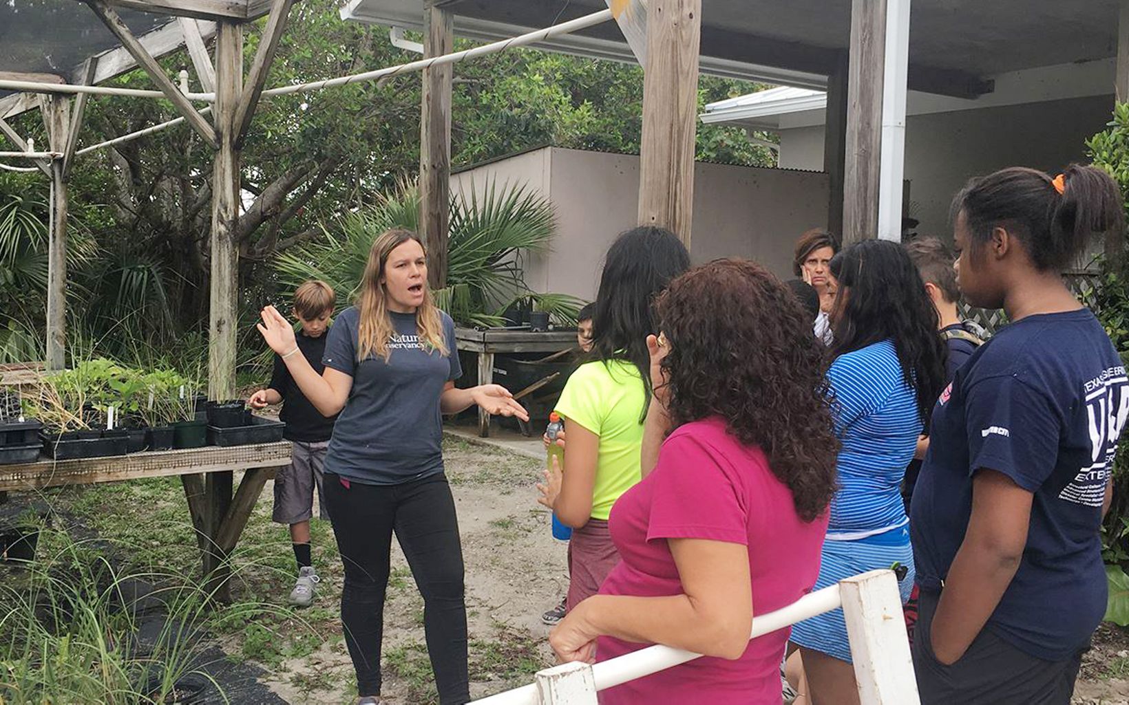 Conservation Education South Florida land conservation manager Sarah Kittredge
teaches middle school students about native plants in the nursery at Blowing Rocks Preserve.  © Rachel Hancock Davis/TNC