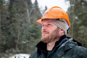 Close up of Chris Stone in the woods wearing his hard hat.