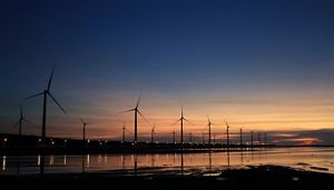 Wind turbines on a shoreline at dawn. 