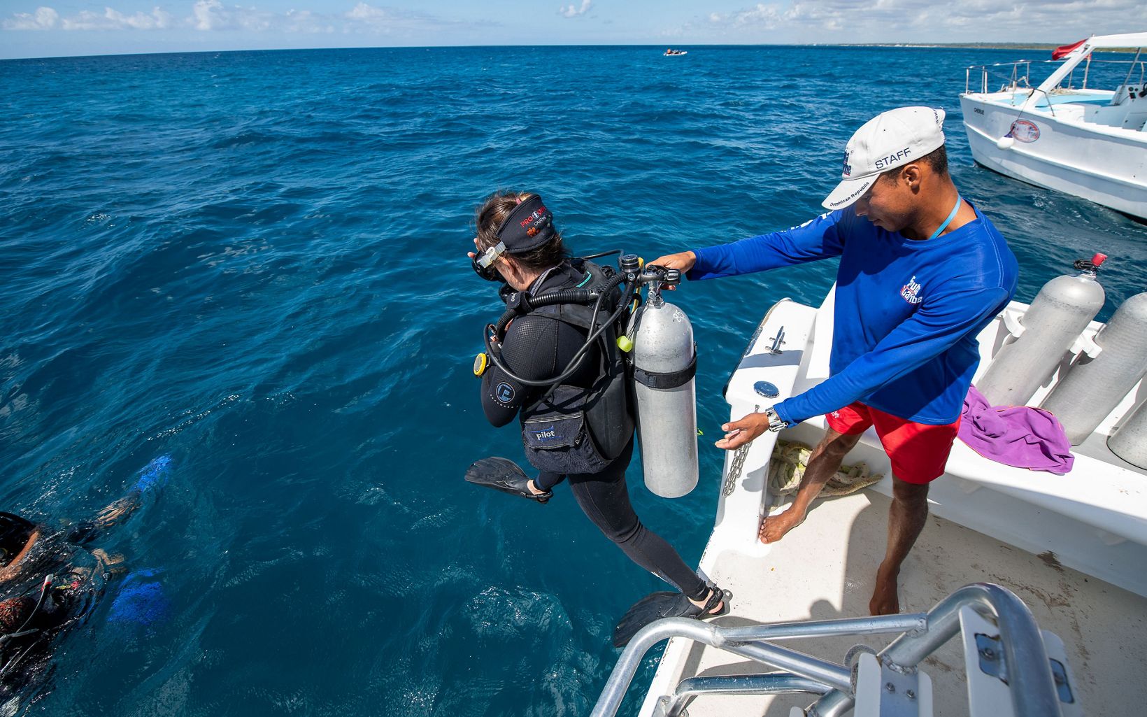 A diver steps off a boat in the Caribbean Sea as part of a coral restoration project off the coast of the Dominican Republic.