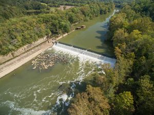 A river flows into a waterfall created by a dam. 