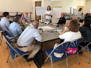 A group of people gather around a meeting table.