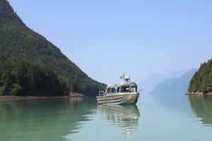 a boat on blue water with mountains in the background