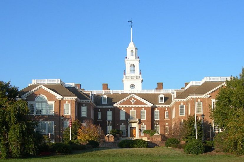 The Delaware state house. A neoclassical brick building with two el wings and a tall white cupola topped with a weather vane.