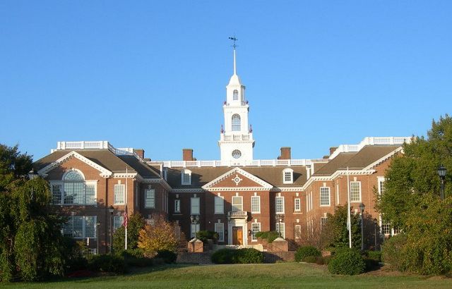 The Delaware state house. A neoclassical brick building with two el wings and a tall white cupola topped with a weather vane.