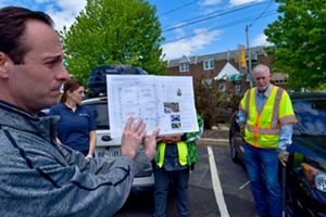 A person holds up a map and points to it.
