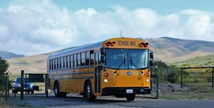 School bus drives through an open gate.