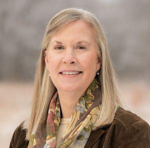 A blonde woman smiling at the camera for a headshot.