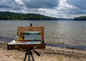 A canvas with a painting of the river in front of the river. 