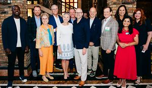 A group of people making up the Florida Board of Trustees pose together and smile at a Philanthropy dinner in Miami, Florida.