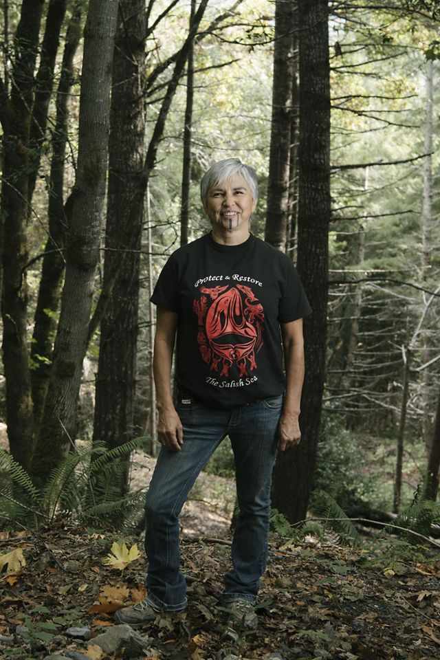 Margo Robbins, a Yurok Tribe member, stands in the forest. 