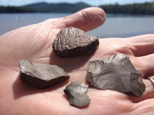 A hand holding artifacts from Indigenous culture.