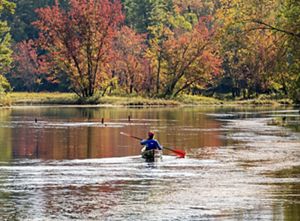 A back shot of a woman on kayak rowing. 