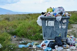 A bin overflows with trash.