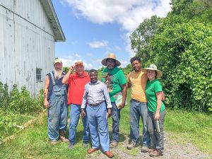 A group of individuals standing together outside on an urban farm.