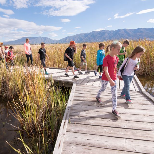 Kids running on a boardwalk at the Great Salt Lake Shorelands preserve.