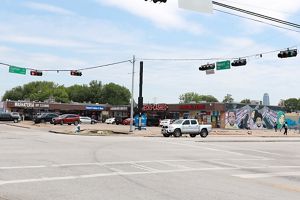 An intersection with paved roads and concrete parking lots.