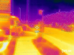 A heat map of a street with cars and nearby buildings and trees.