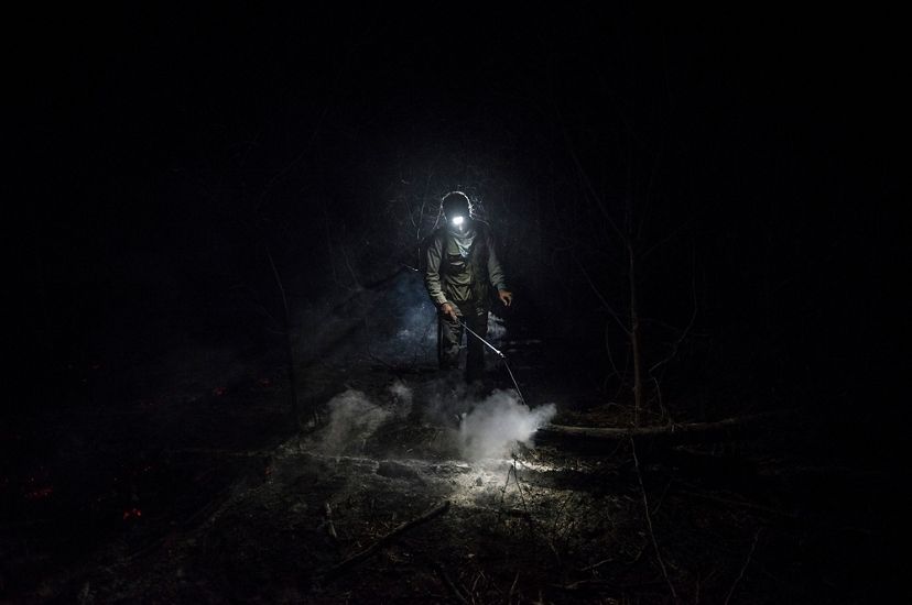 Volunteer forest firefighter Daniel Vargas Osinaga (21) walks through thick smoke after helping to extinguish a fire in Bolivia's Santa Rosa de Tucabaca.