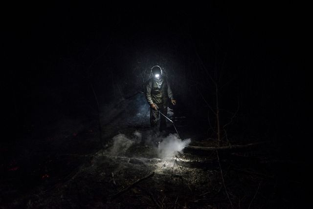 Volunteer forest firefighter Daniel Vargas Osinaga (21) walks through thick smoke after helping to extinguish a fire in Bolivia's Santa Rosa de Tucabaca.