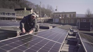 A man works on solar panels on a roof in Kentucky.